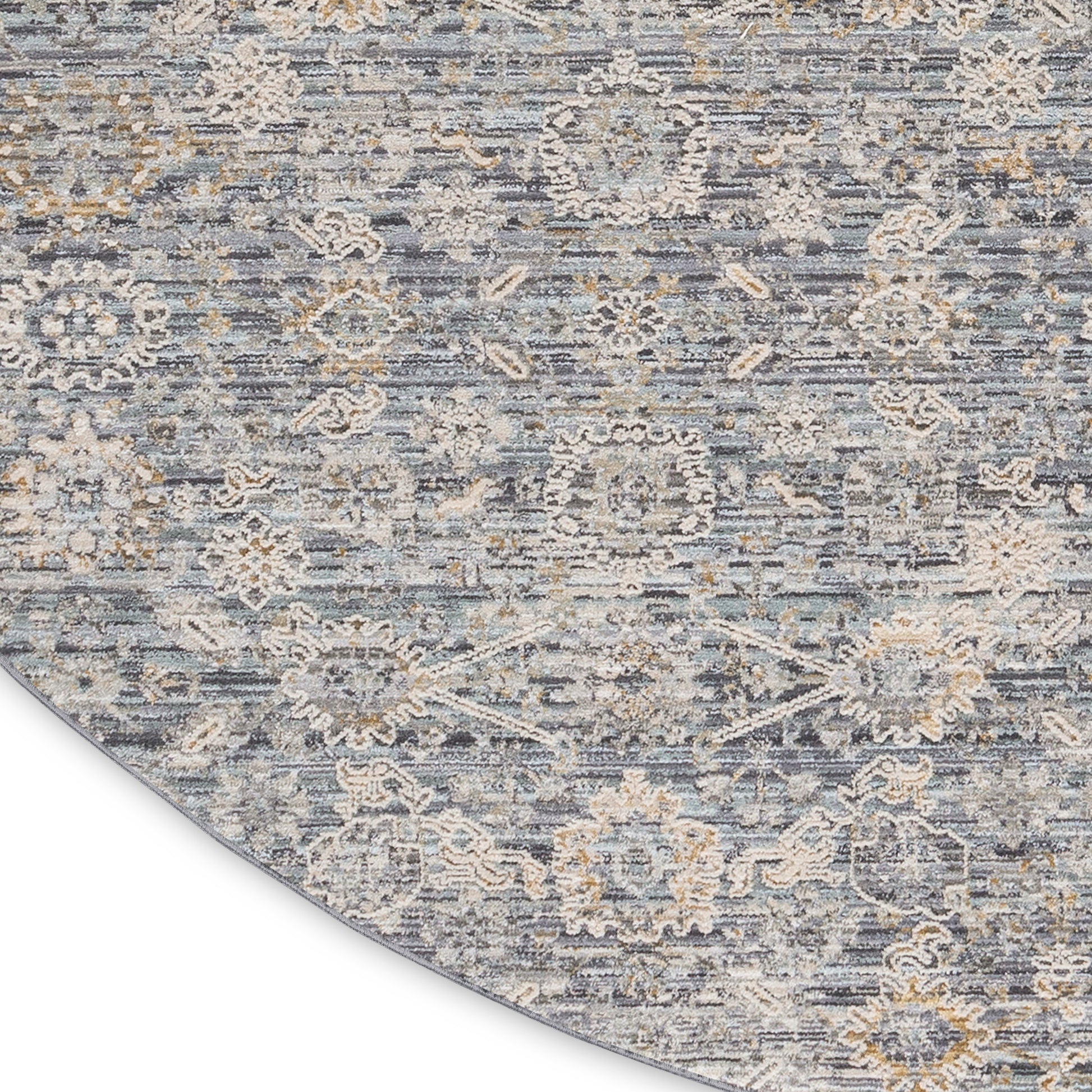 Round blue-gray rug with beige floral medallions and distressed pattern, soft textured.