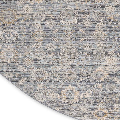 Round blue-gray rug with beige floral medallions and distressed pattern, soft textured.