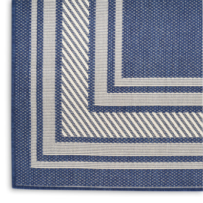 Blue & white rug with striped borders forming concentric square patterns; textured surface.