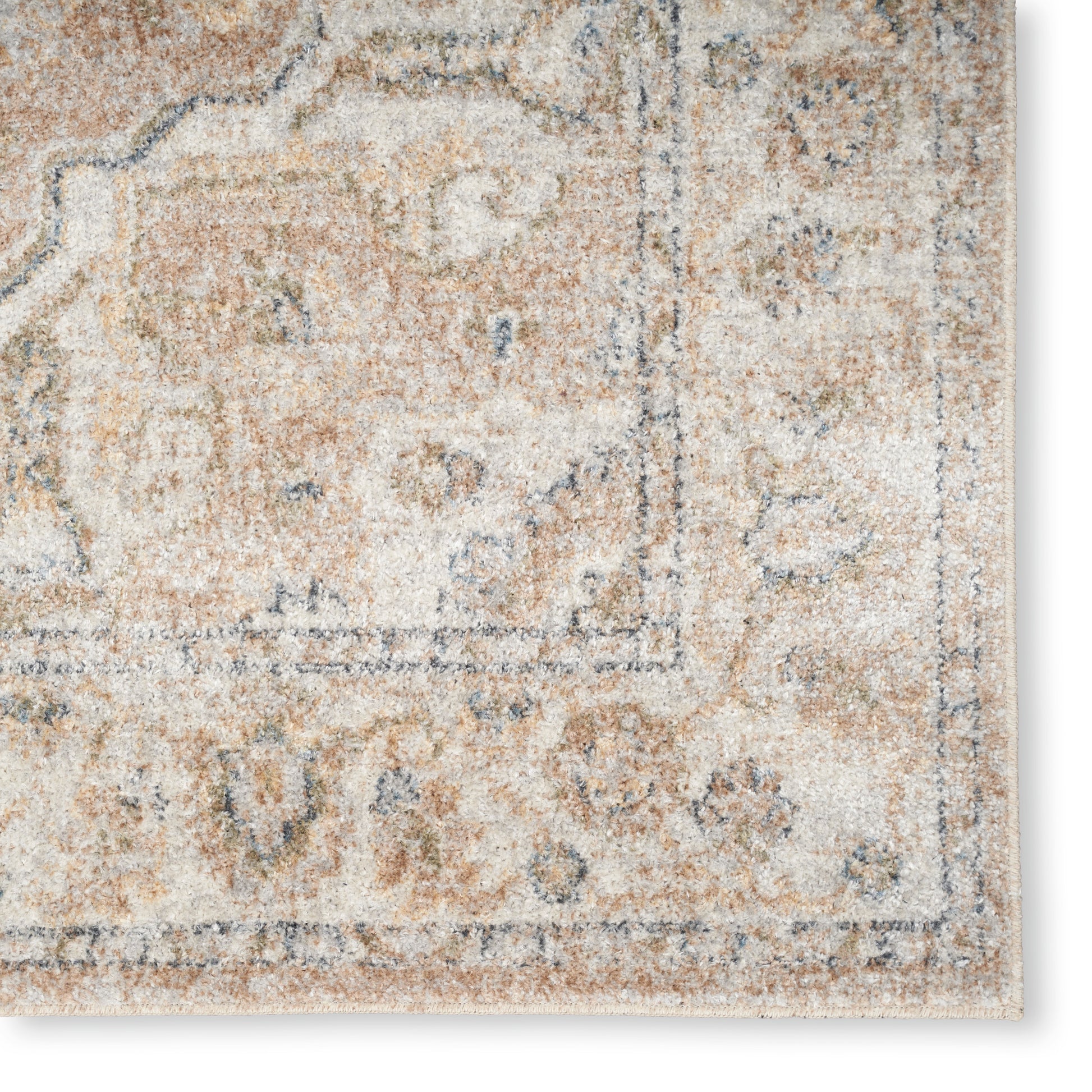 Distressed beige oriental rug with muted blue motifs and decorative border; corner view, soft plush pile.