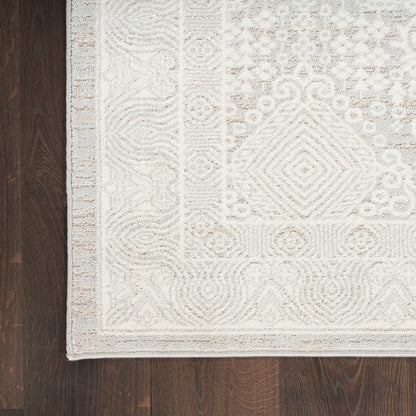 Cream-beige woven area rug with textured geometric motifs & a subtle border, rectangular on dark wooden floor.