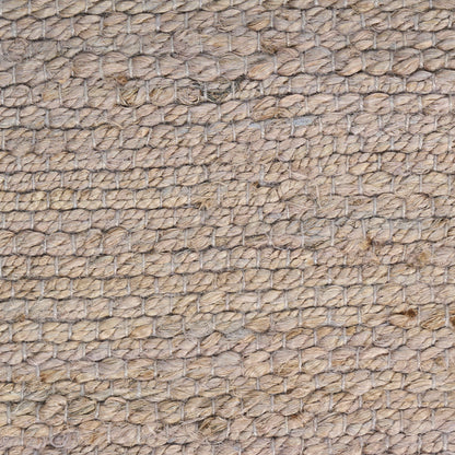 Beige jute rug close-up with braided loop weave, natural fibers and rustic coastal appeal.