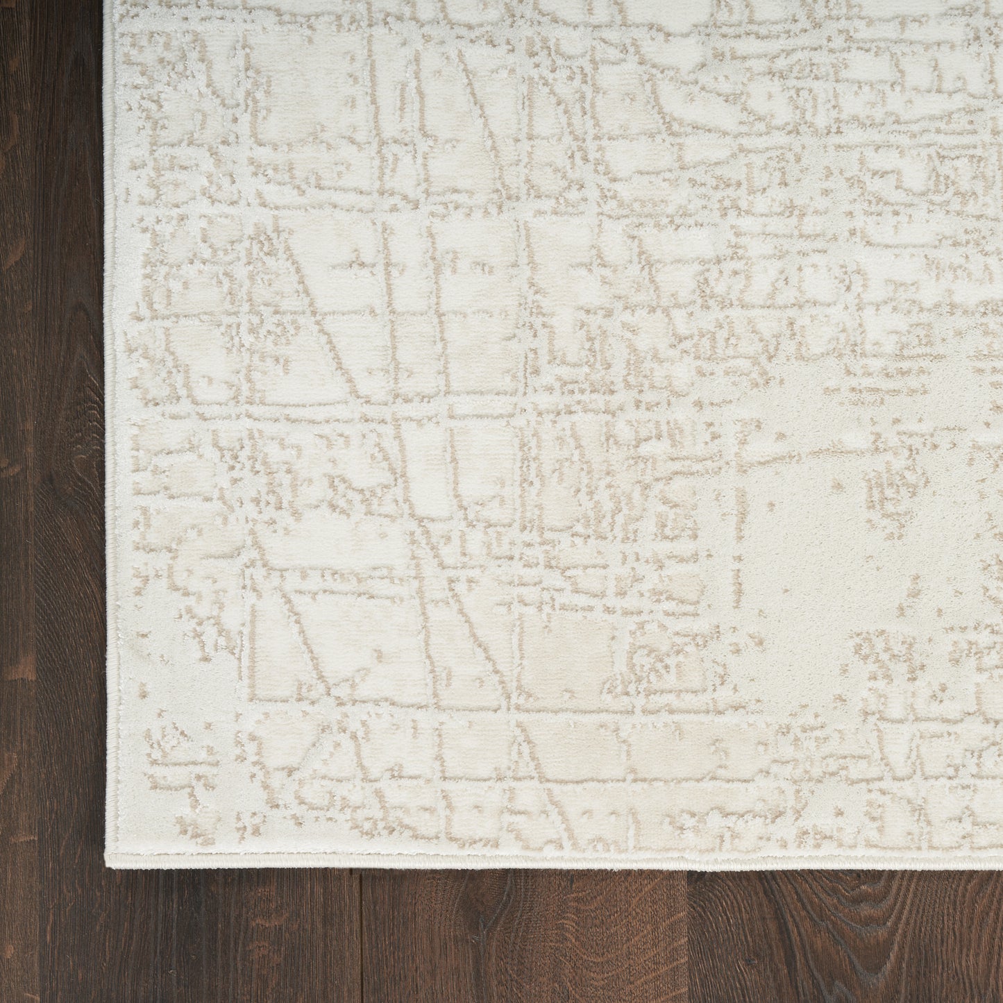 Rectangular beige area rug (8' x 10') with a soft, textured geometric pattern on dark wood floor