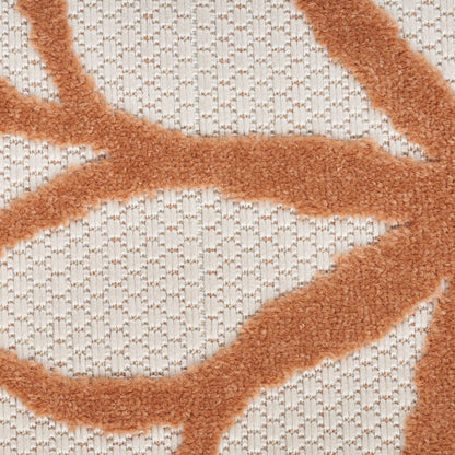 Close-up of beige knitted fabric with orange fuzzy chenille lines forming abstract branch patterns.