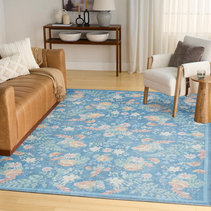 Blue floral area rug over light hardwood floor with tan leather sofa, gray accent chair, and wooden console table.