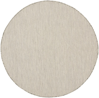 Beige round woven rug with subtle diamond texture; natural, casual home decor.