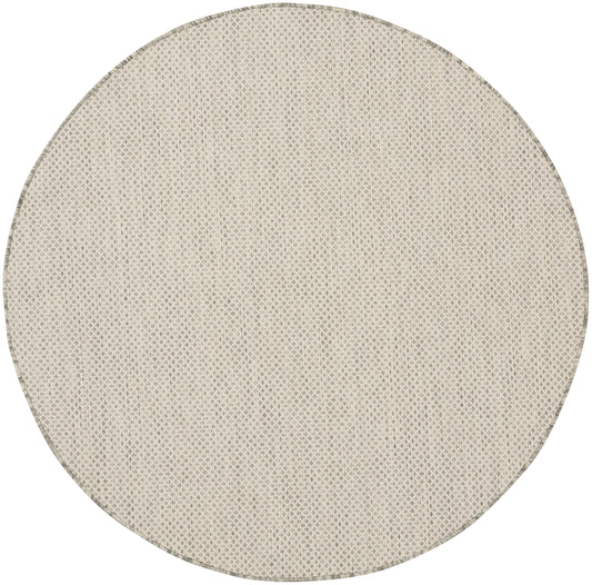 Beige round woven rug with subtle diamond texture; natural, casual home decor.