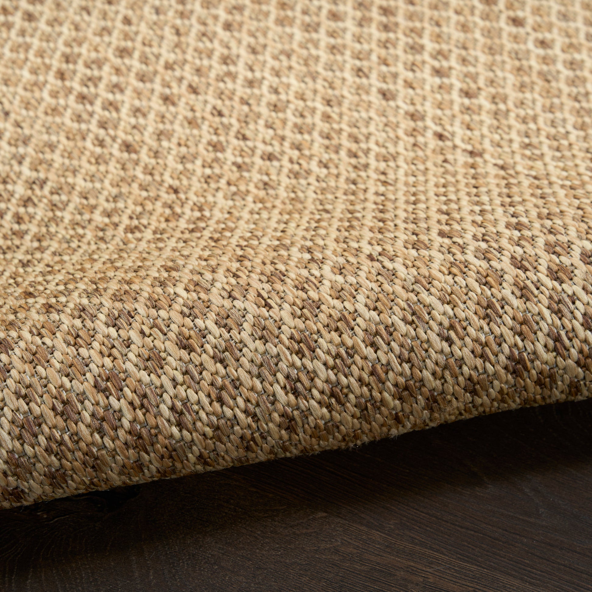Natural beige jute rug, rectangular flat weave with rolled edge, rustic coastal decor for living spaces.