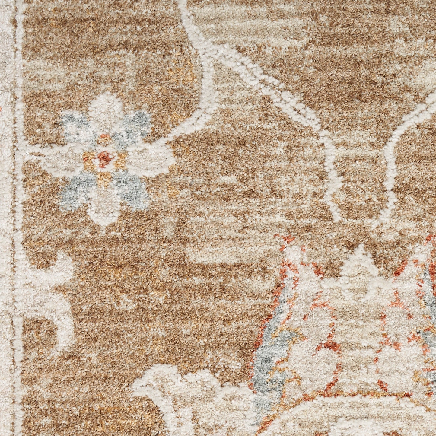 Tan-brown area rug with cream floral motifs and a light blue flower accent; Persian-style decorative pattern.