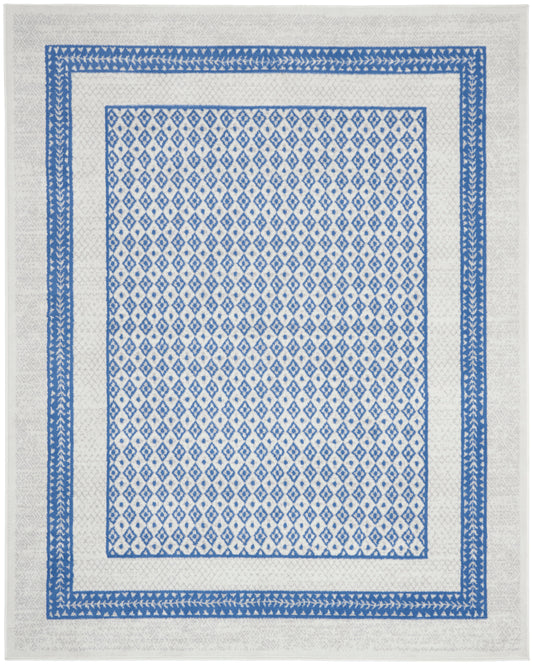 Blue and white geometric rug with dense diamond pattern framed by layered blue borders on a light cream field