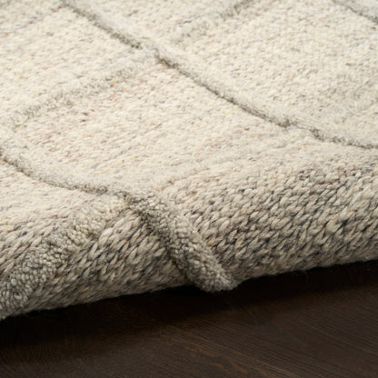 Cream beige textured area rug with thick loop pile and braided edge on dark wood floor.