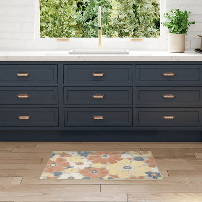 Navy blue nine-drawer kitchen cabinets with brass pulls, white countertop, gold faucet, and colorful floral rug on wood floor.