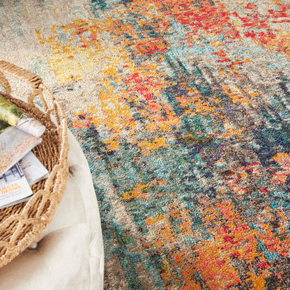Colorful abstract-pattern rug with orange, teal, blue and yellow; wicker basket with magazines on a light ottoman.