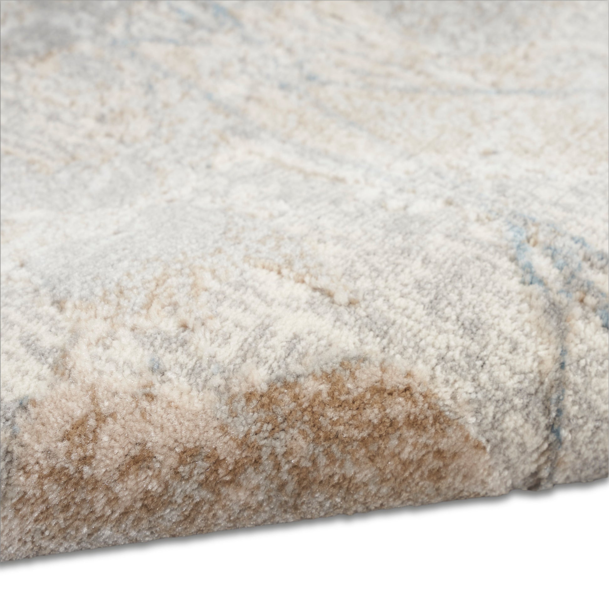 Close-up of a plush beige, ivory and light blue rug with a soft shaggy pile and folded edge.