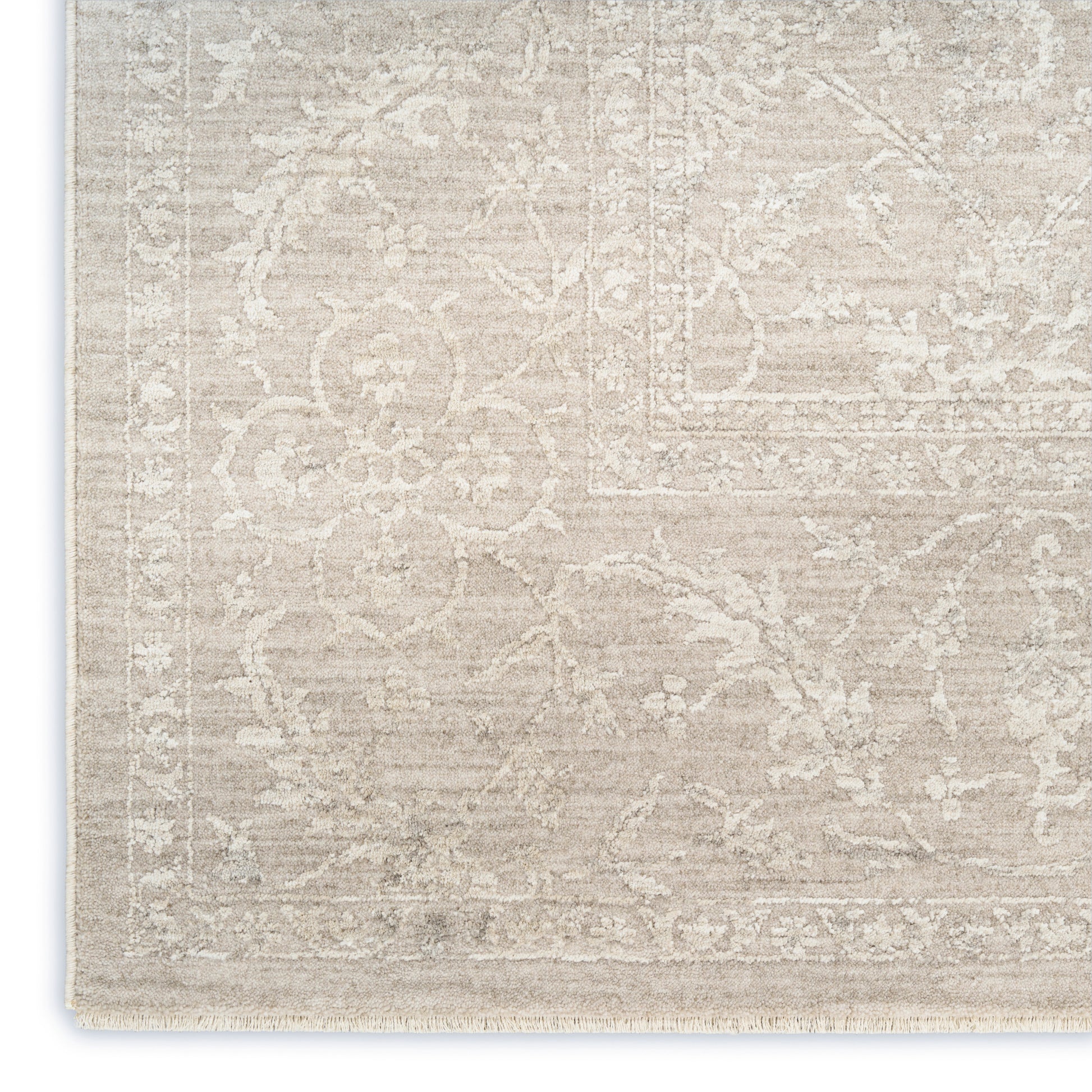 Beige traditional oriental rug with ivory floral damask pattern, fringed edge, soft woven look for living room decor.