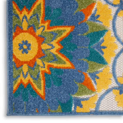 Tufted area rug with a bold multicolor floral starburst in orange, yellow, teal and blue, bordered in blue.