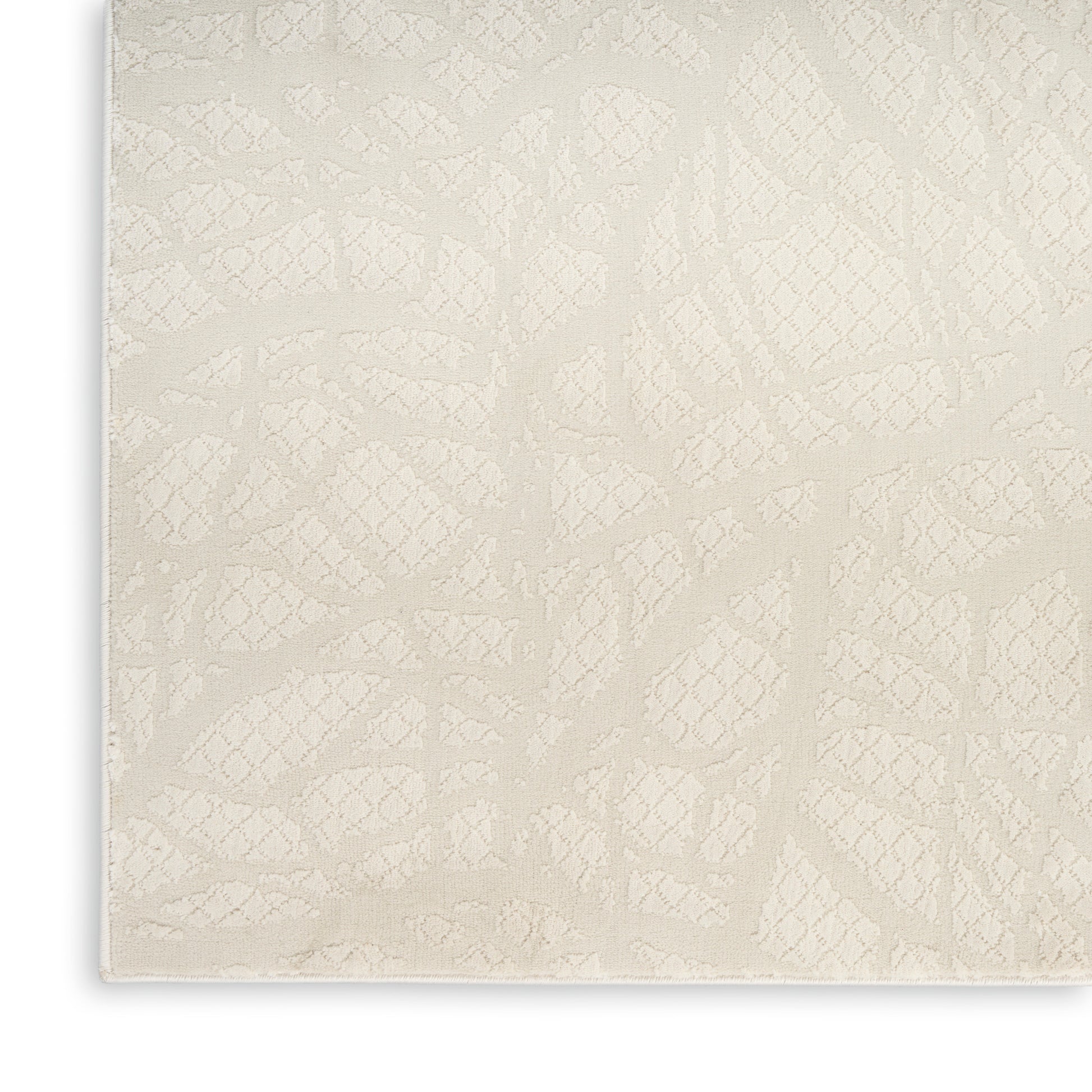Cream jacquard fabric close-up with subtle raised diamond lattice pattern.
