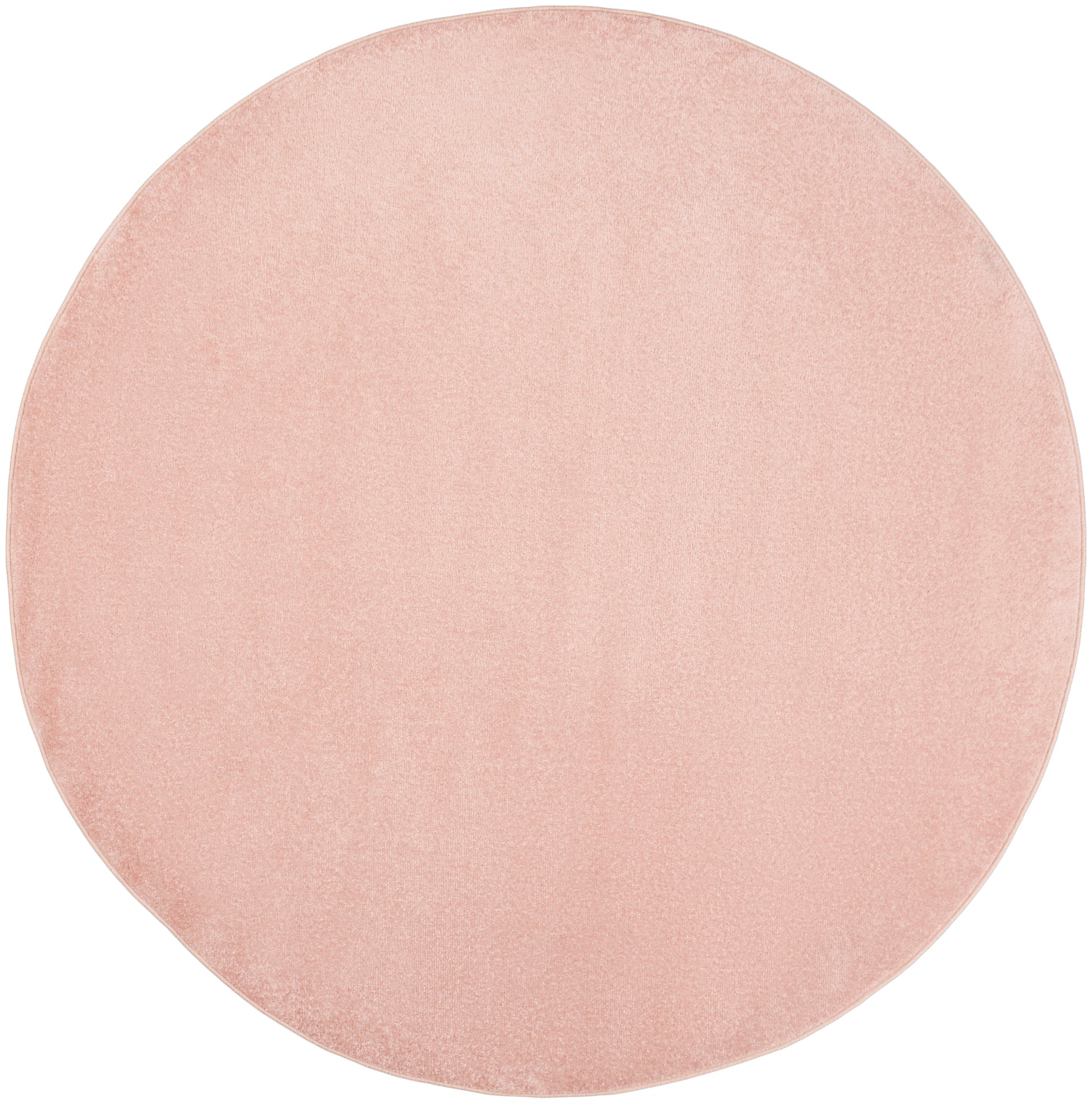 Round blush pink outdoor rug with textured surface.
