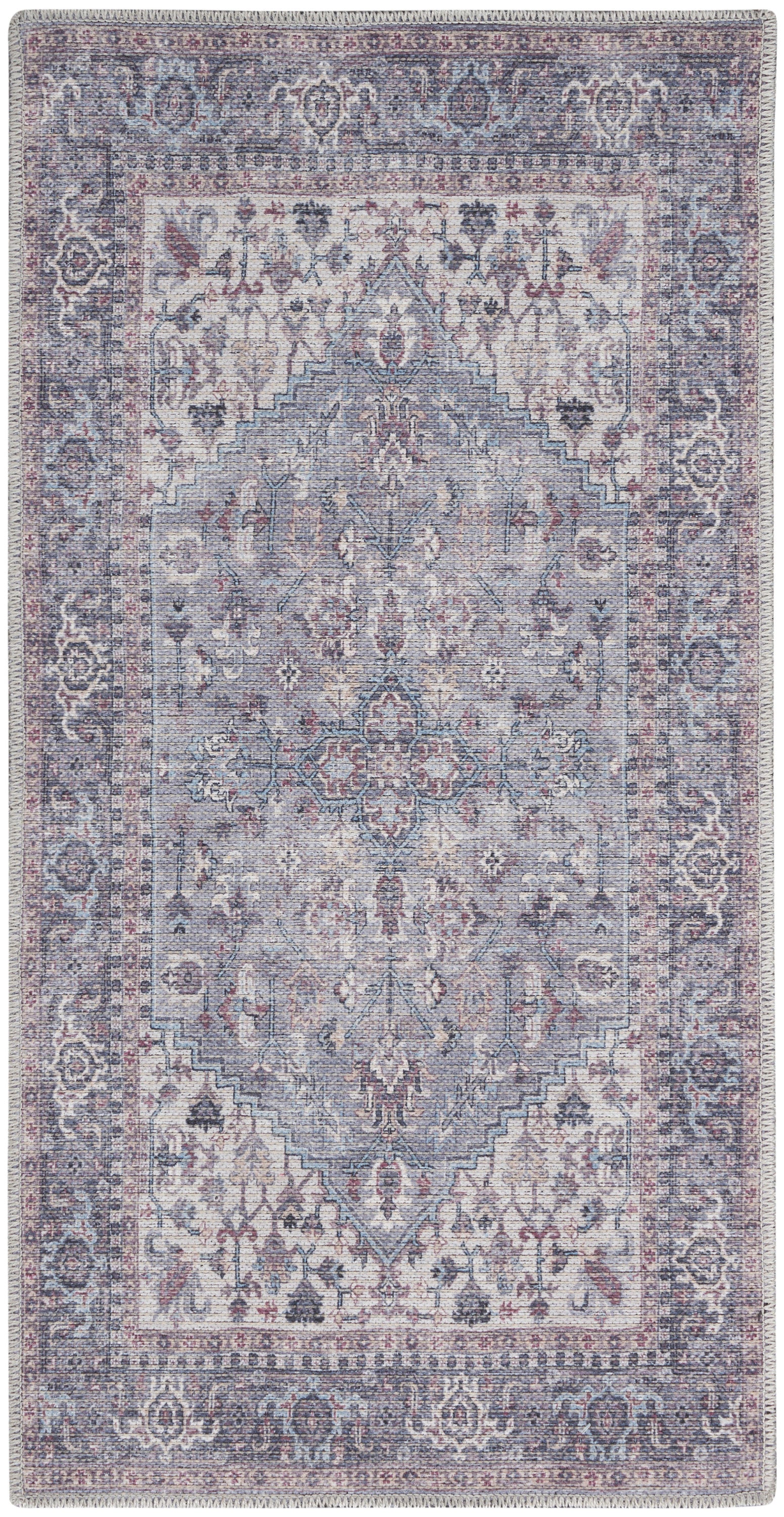 Rectangular vintage-inspired Persian rug in muted blue, lavender and ivory with a floral medallion pattern and fringed edges.
