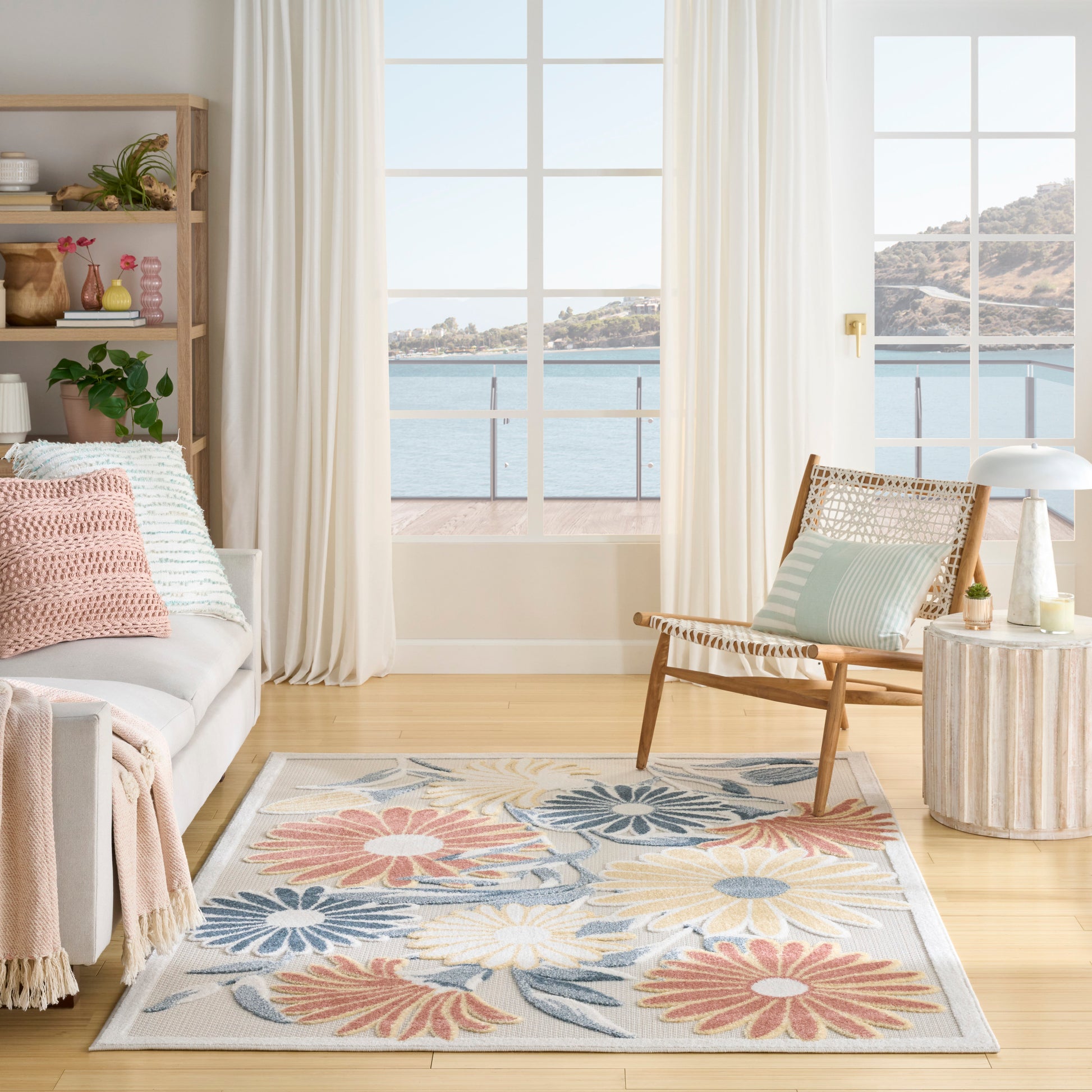 Rectangular soft-pile pastel floral area rug with pink, blue, and yellow blossoms; coastal living room scene.