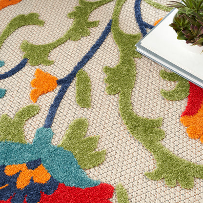 Beige woven rug with lime green vine patterns, blue & orange accents; stack of books with a succulent on top.