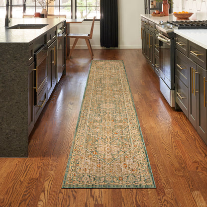 Long beige kitchen runner rug with teal border and geometric motifs on a hardwood floor between dark cabinets.