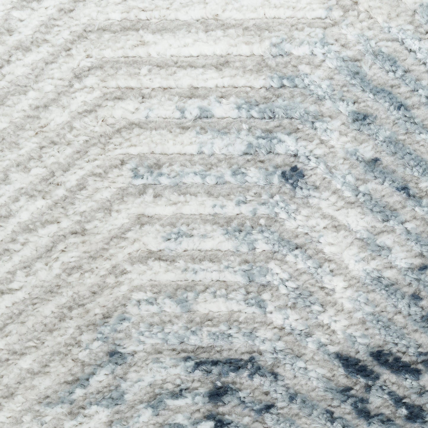 Soft shag rug in white, light gray and blue tones with a subtle wavy stripe pattern.