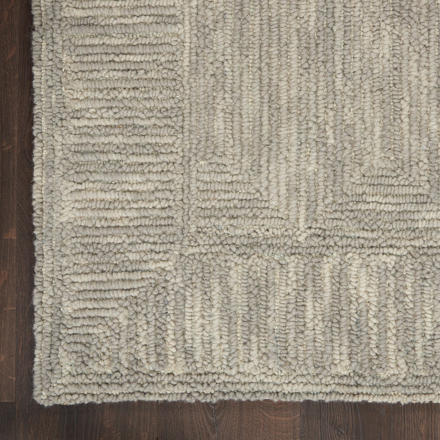 Neutral beige-gray geometric shag rug with chunky looped pile and rectangular block pattern on dark wood floor