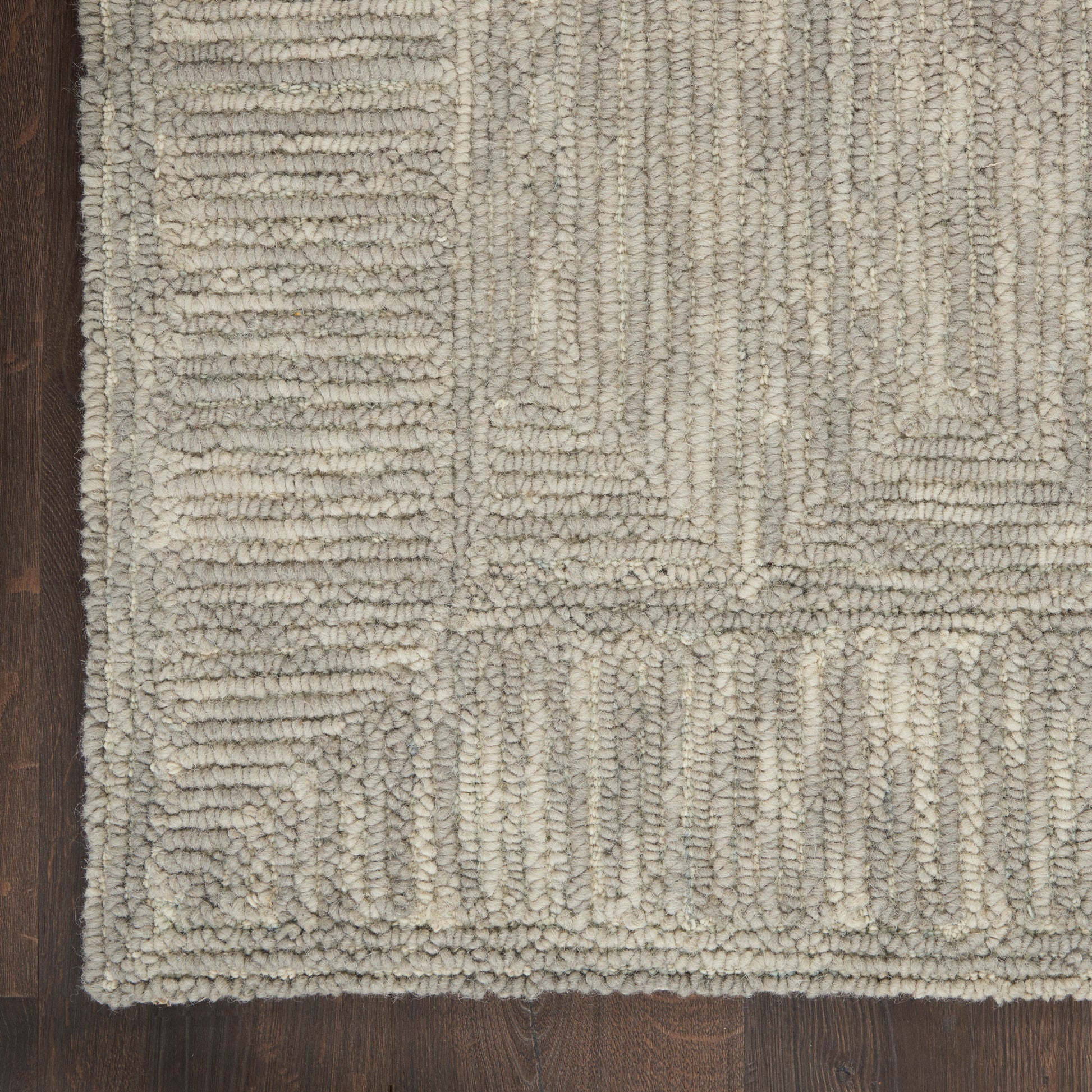 Neutral beige-gray geometric shag rug with chunky looped pile and rectangular block pattern on dark wood floor