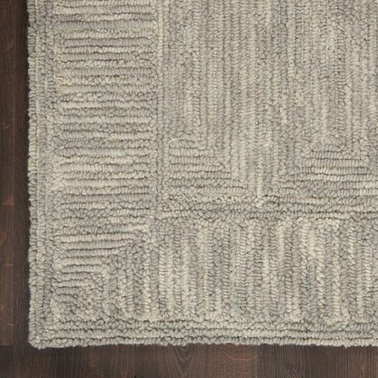 Neutral beige-gray geometric shag rug with chunky looped pile and rectangular block pattern on dark wood floor