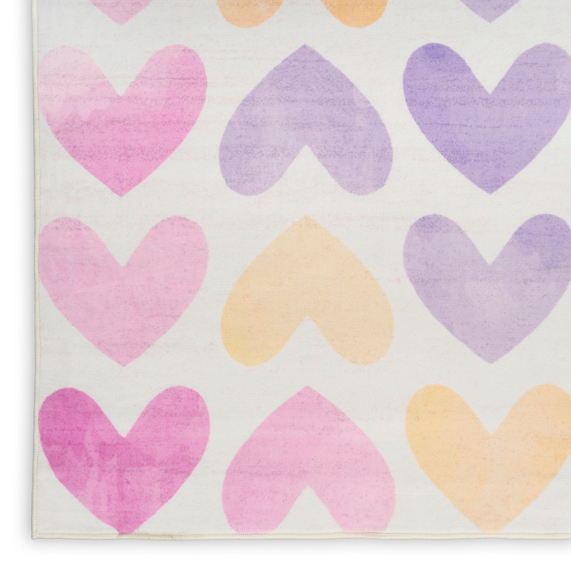 Pastel heart pattern on a light rug with pink, lavender, and peach hearts and a visible bound edge.