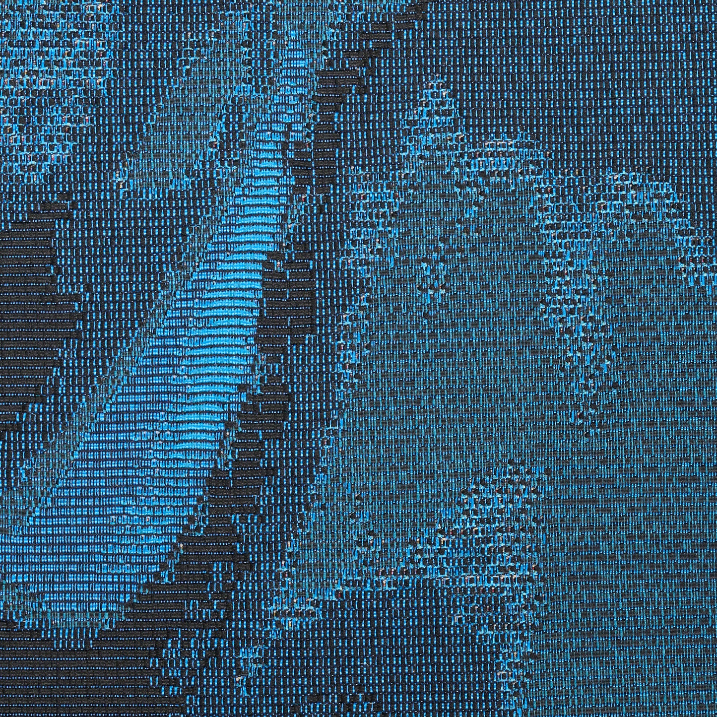 Close-up of a blue and teal woven rug with geometric patterns and diagonal stripe accents.