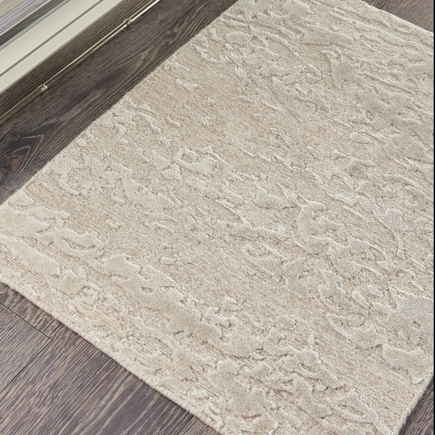 Beige textured rectangular area rug with soft plush pile, cream pattern, ideal for living room on dark wood floors.