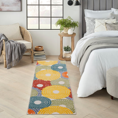 Long flat-weave runner with multicolor concentric circles in yellow, blue, orange and red, in a bright bedroom.