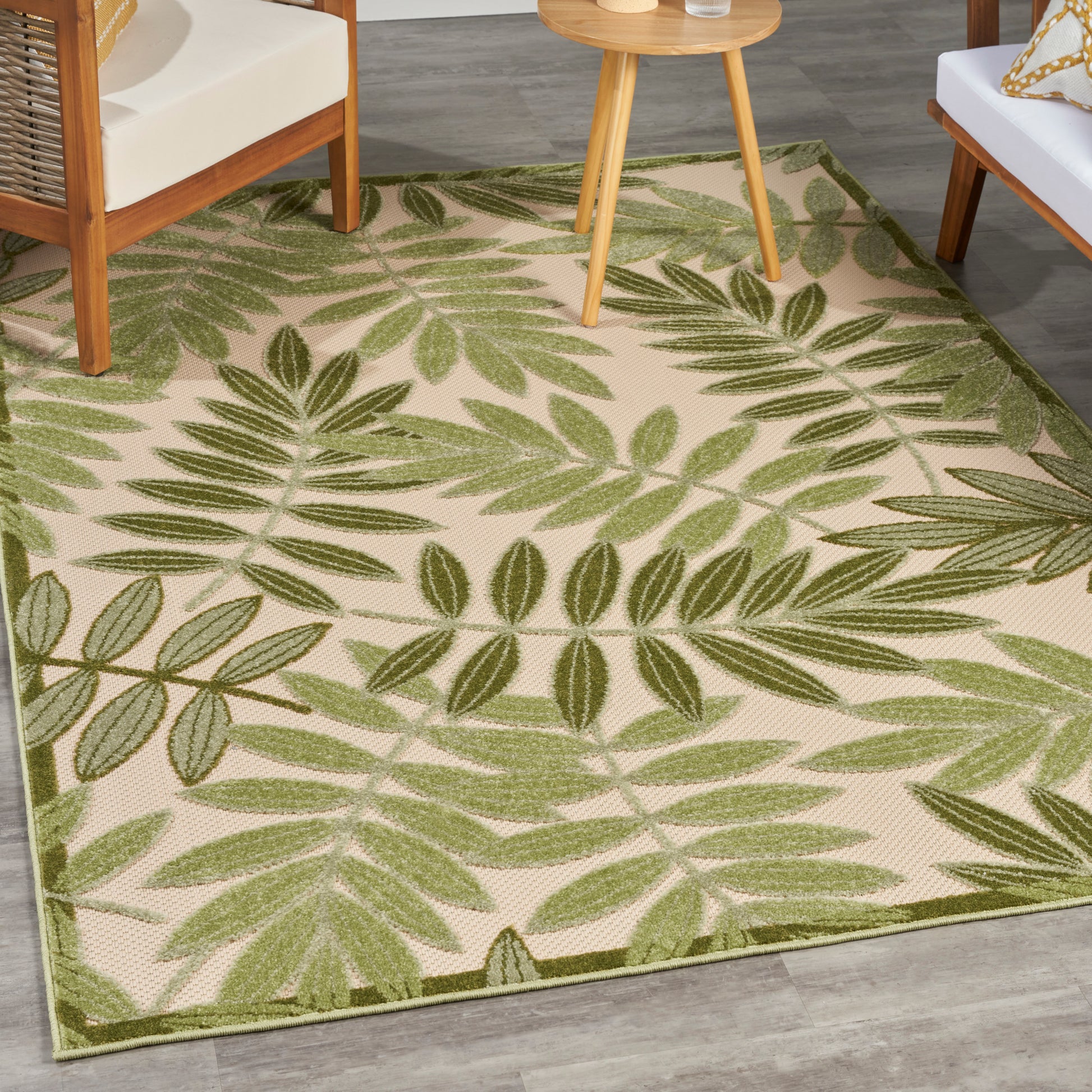 Beige rectangular area rug with bold green palm leaf pattern and green border; ideal living room decor.