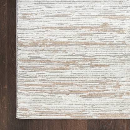 Cream and taupe striped area rug with soft textured pile on dark hardwood floor.