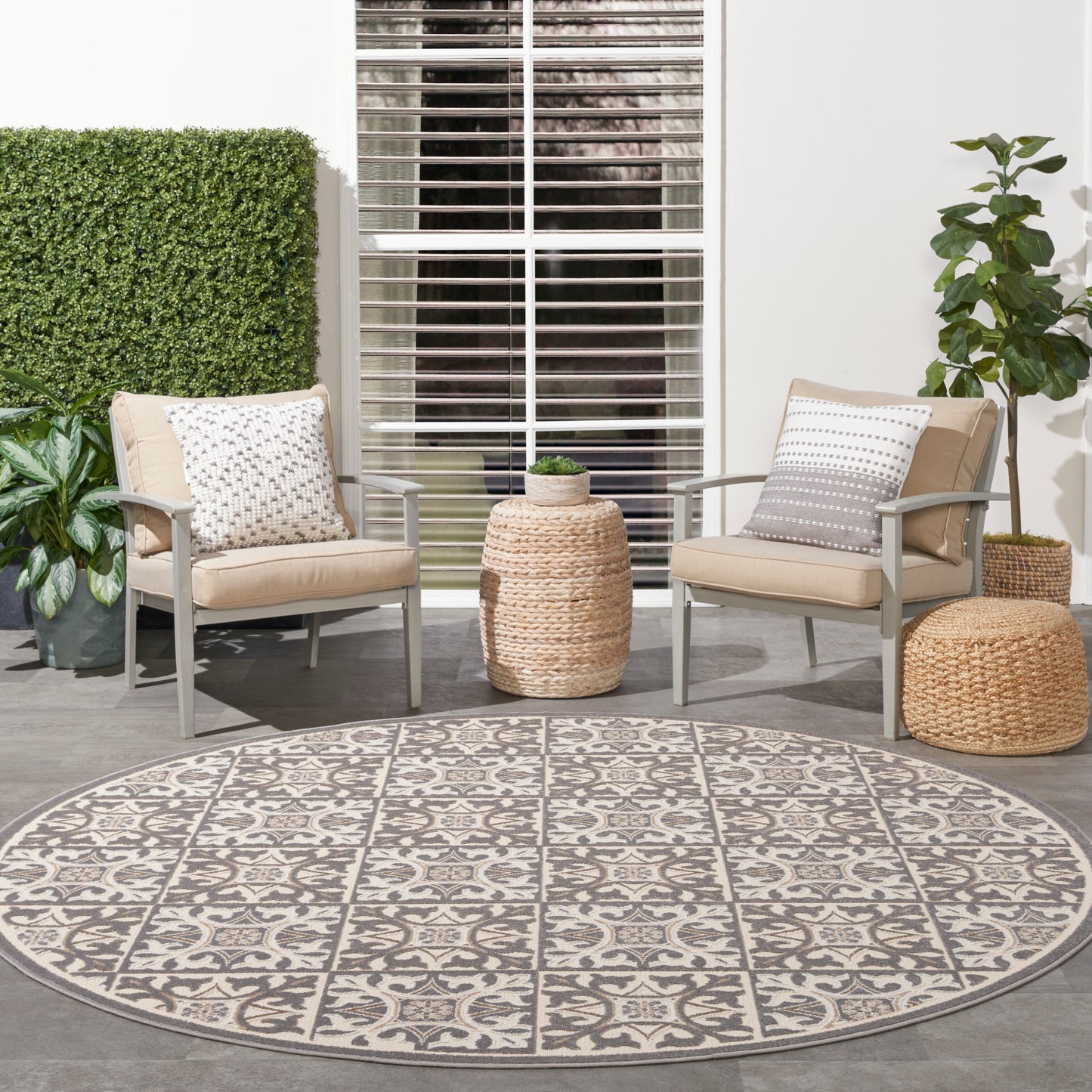Round geometric outdoor rug, 8 ft diameter, shown on a patio with plants.