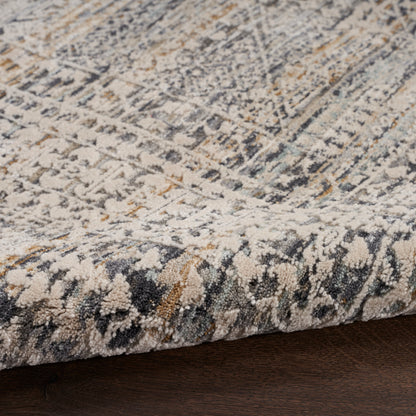 Textured area rug with a distressed geometric pattern in ivory, gray, navy and gold; low-pile and cozy.