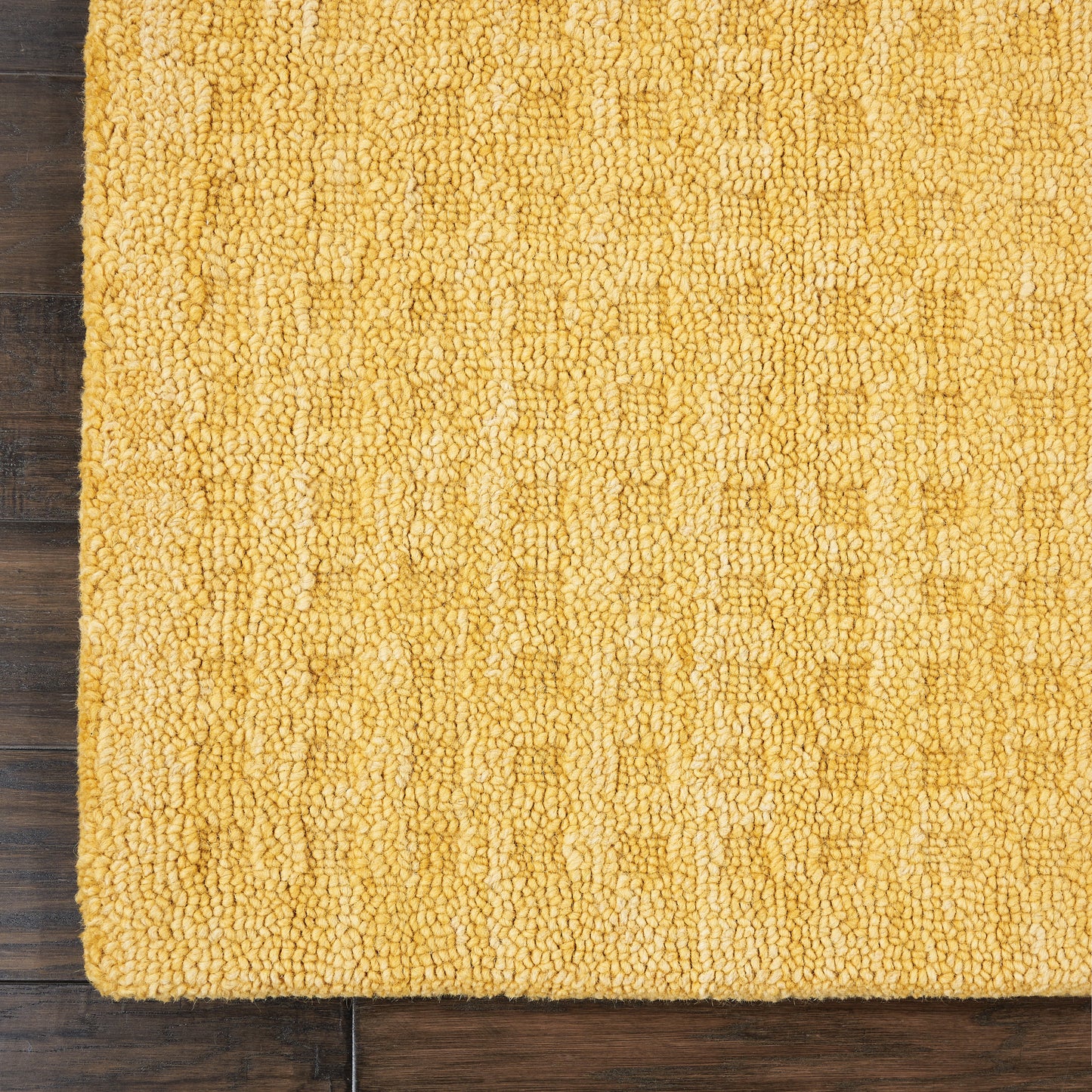 Mustard-yellow shag runner rug with dense looped pile on dark wood floor.