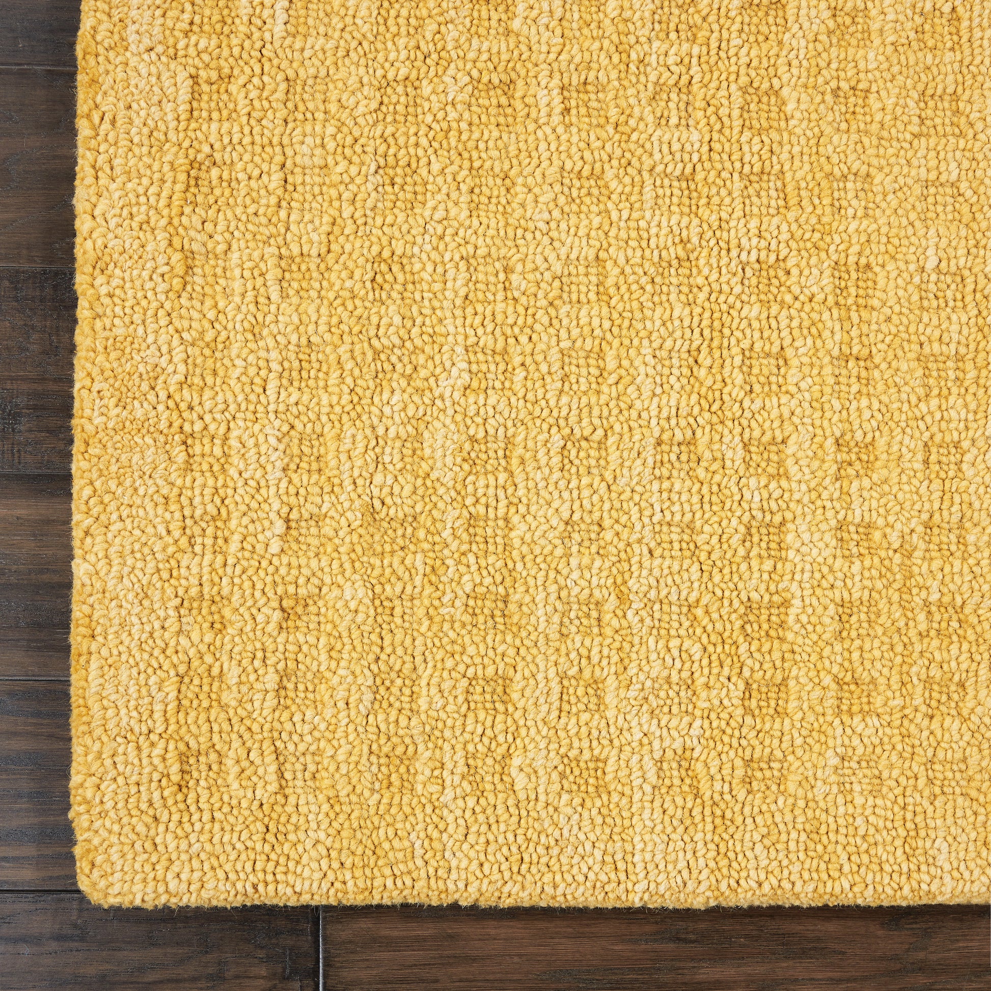 Mustard-yellow shag runner rug with dense looped pile on dark wood floor.