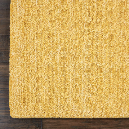 Mustard-yellow shag runner rug with dense looped pile on dark wood floor.