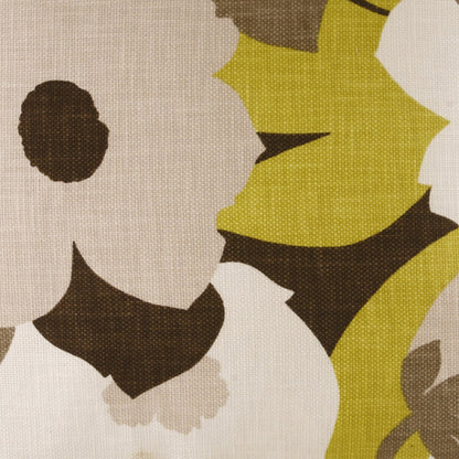 Abstract floral fabric print with large cream petals, brown centers, lime and tan leaves on beige textured background.