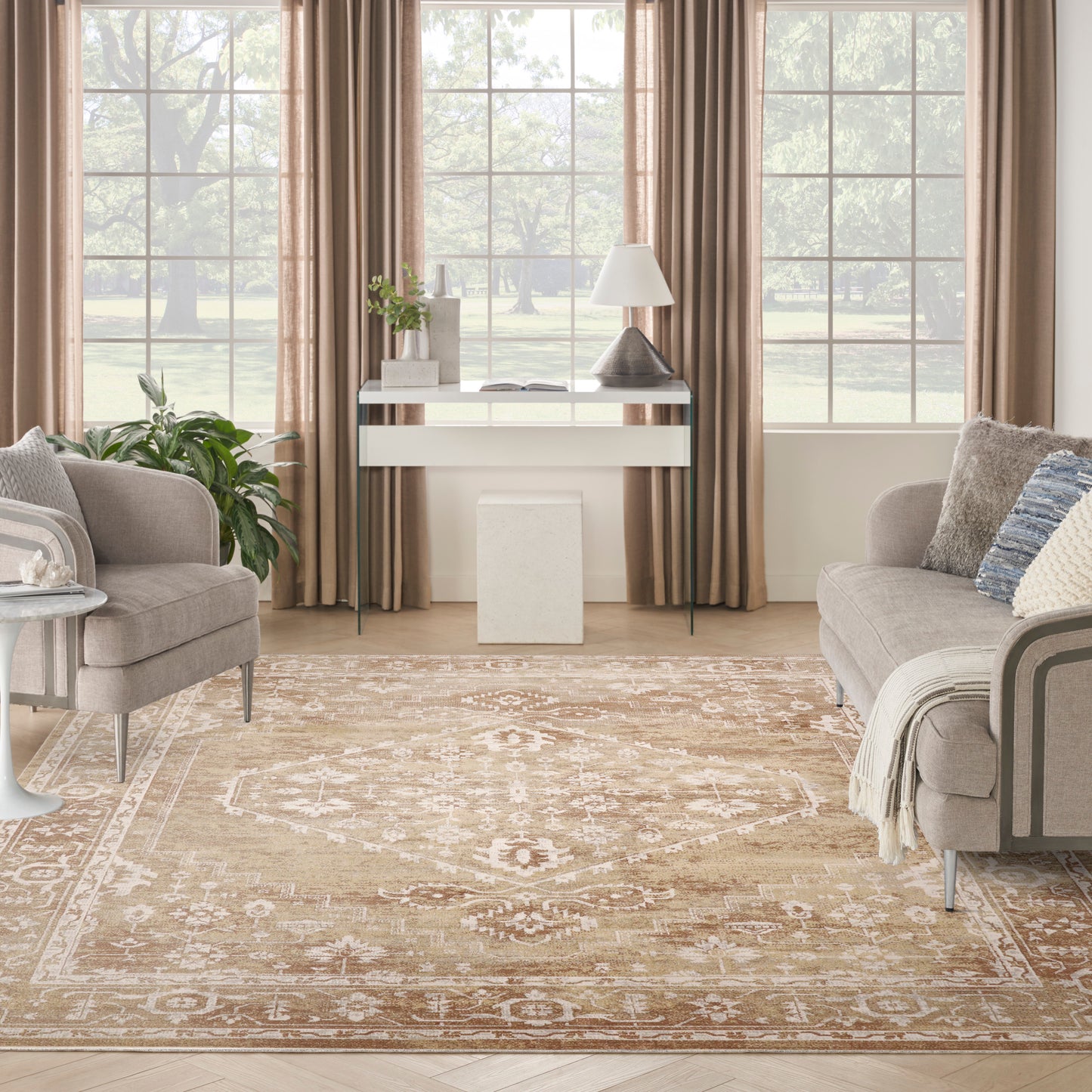 Neutral living room with beige curtains, glass-and-white console, gray upholstered chairs, and a patterned beige rug.