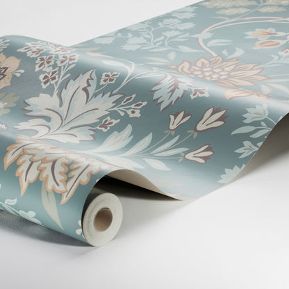 Rolled wallpaper with teal blue background and pale peach and ivory floral pattern, partially unrolled on white surface.