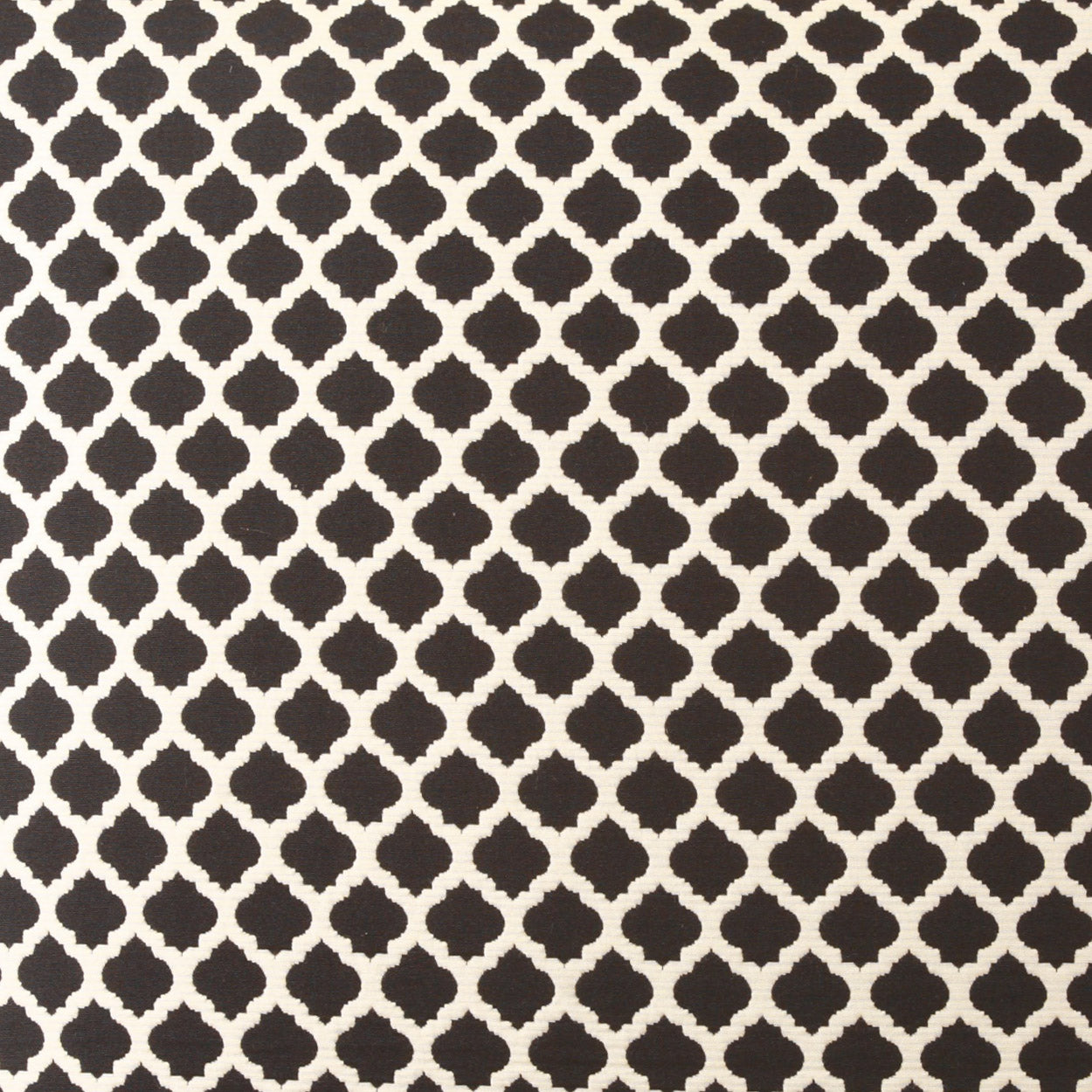 Dark brown quatrefoil lattice pattern on beige fabric.