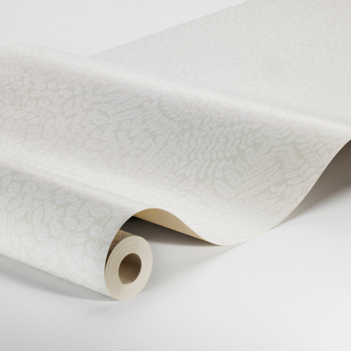 Cream wallpaper roll with subtle white botanical pattern, curved sheet and visible core, elegant home decor.