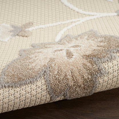 Beige woven jute rug with white starfish pattern, low-pile farmhouse style, folded on dark wood floor.