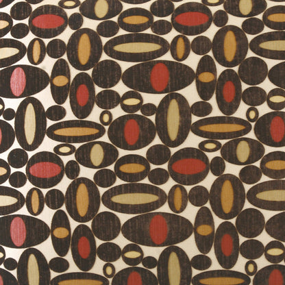Retro fabric pattern of black oval shapes with inner red, pink, tan, or olive ellipses on a cream background.