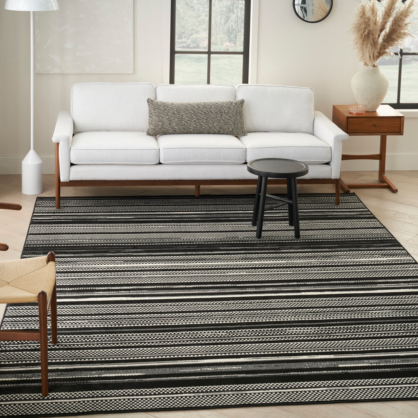 5' x 7' black-and-white striped rug in a modern living room with a small round black coffee table.