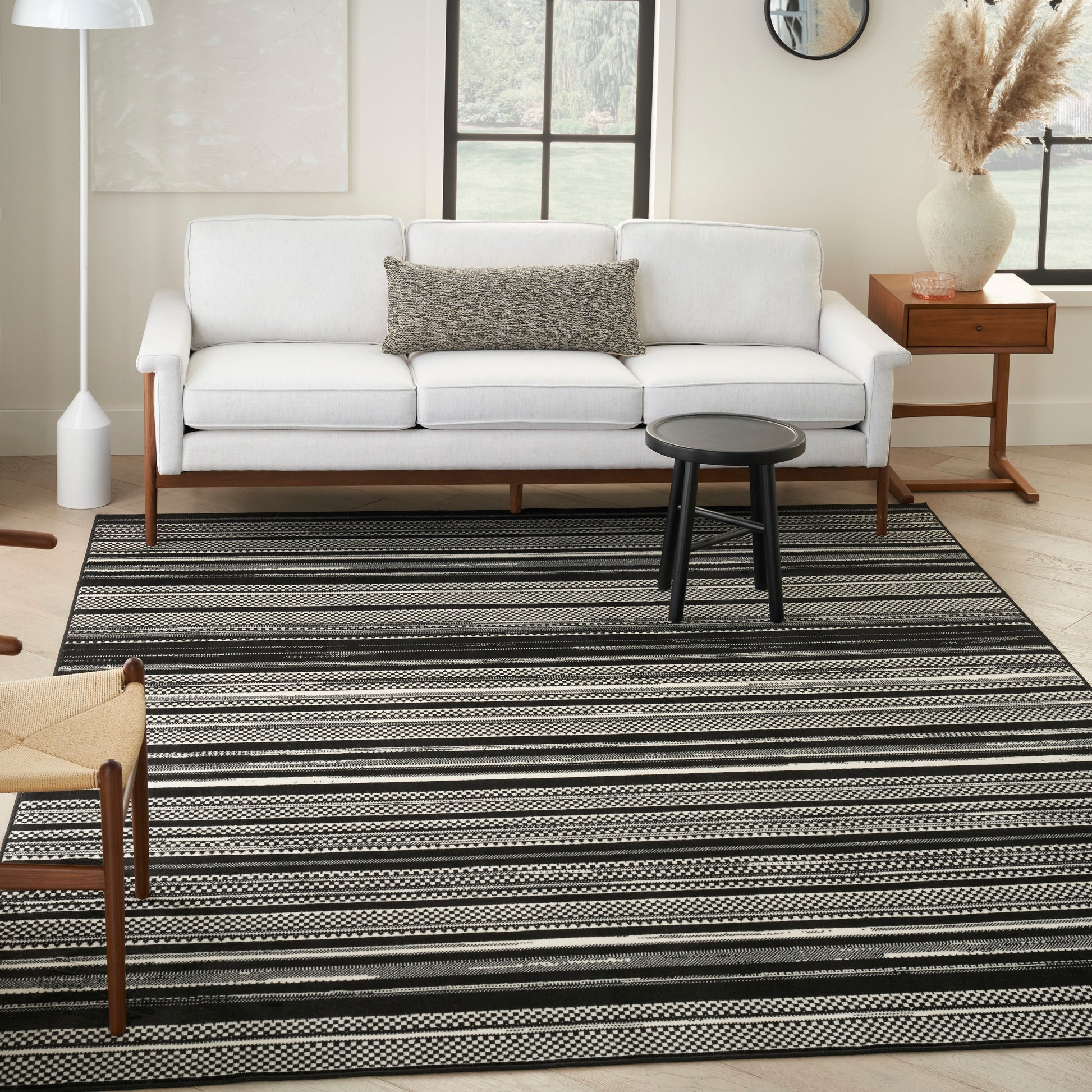 5' x 7' black-and-white striped rug in a modern living room with a small round black coffee table.